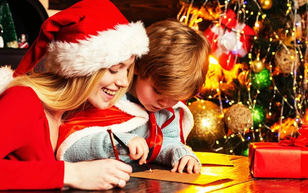 Christmas Child son and mother Write Letter to Santa Claus. Lovely mother is writing a letter to Santa with her son. Happy Christmas family. — Stock Photo, Image