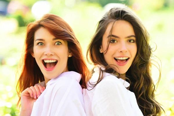 İki heyecanlı kadın arkadaş yeşil doğada poz veren kızlar. Halk yaşam tarzı konsepti. — Stok fotoğraf
