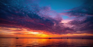 Güzel gün doğumu. Akşamüstü denizde yelkenli teknesi güzel büyük dağların ardından arka plan, lüks yaz macerası, aktif tatil..