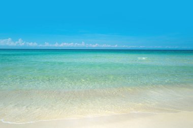 Mavi gökyüzü kumlu deniz kumsalı.