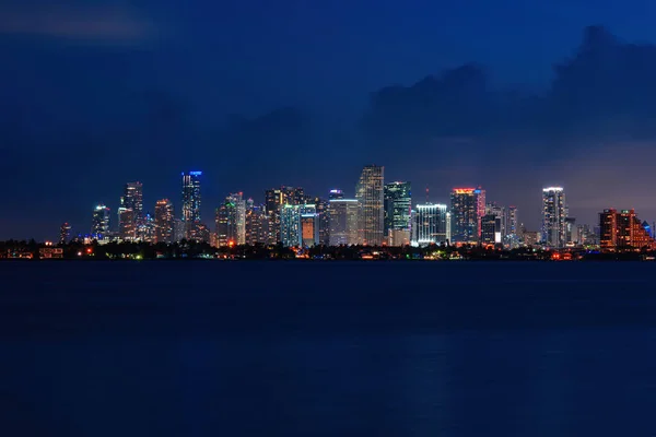 Skyline cidade miami iluminação luzes mar oceano pôr do sol noite cityscape edifícios centro da cidade, arquitetura arranha-céu crepúsculo panorama. Miami. . — Fotografia de Stock