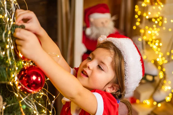 Vacker kvinna dekorera julgran med grannlåt - nyårstradition. Julbarn dekorera med grannlåt eller julboll. Nyårs- och julbarnskoncept. — Stockfoto