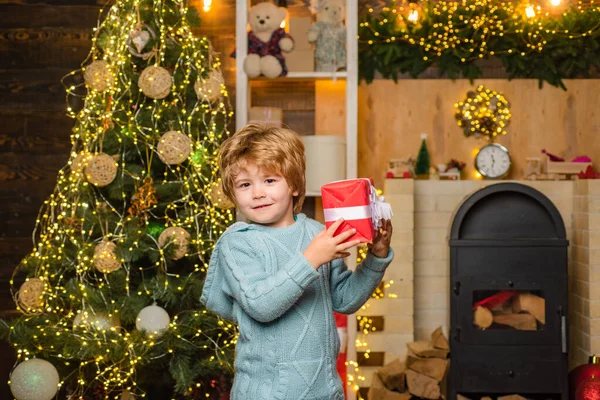 クリスマスプレゼント付きの幸せな子供。幸せな子供は贈り物を楽しんでいます。クリスマスの飾り。クリスマスをお祝いします。クリスマスの子供たち。プレゼントで楽しいお子様モデル. — ストック写真