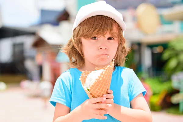 Criança comendo sorvete no café. Kid hold grande sorvete em waffles cone com rosto engraçado . — Fotografia de Stock