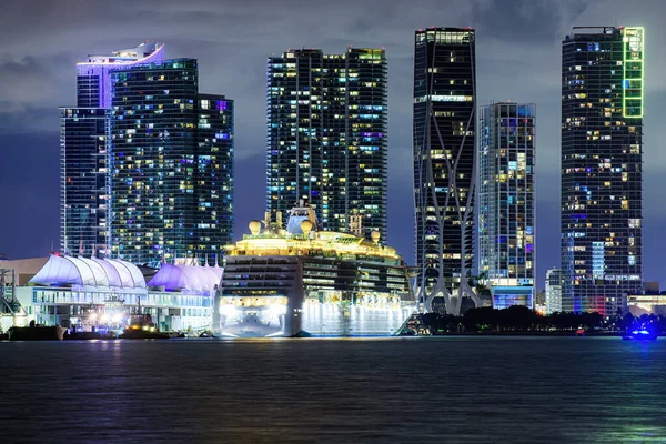 Miami kväll nere i stan. Kryssningsfartyg i hamnen i Miami vid solnedgången med flera lyxbåtar. Nattutsikt över kryssningsfartyg nära Miami Port. — Stockfoto