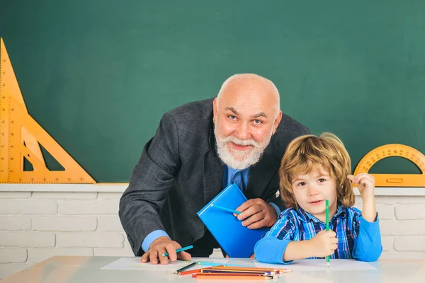 Insegnante Nonno con allievo in fondo all'aula della scuola elementare. Giorno di insegnanti. — Foto Stock