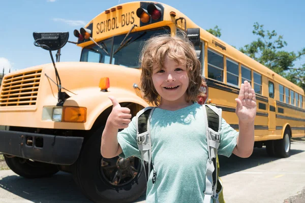 Schulbus. Fröhlich lächelnder kleiner Junge mit Rucksack, der Spaß am Schulbus hat. Schulkonzept. Zurück zur Schule. — Stockfoto