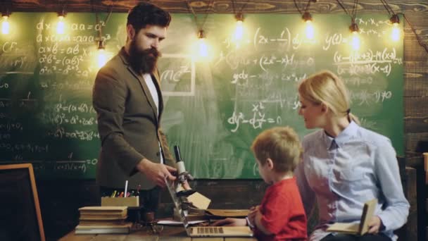 Madre padre e hijos juntos, padres ayudando con la tarea. Educación en el hogar. — Vídeos de Stock