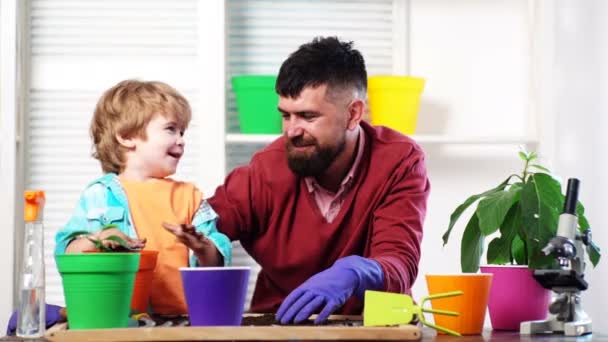 Blumen pflanzen. Wenig Helfer im Garten. Bauernfamilie. Vater und Sohn im Hintergrund der Natur. Gartengeräte. Familienhobby Gartenarbeit. Papa lehrt kleinen Sohn Pflanzen pflegen. — Stockvideo