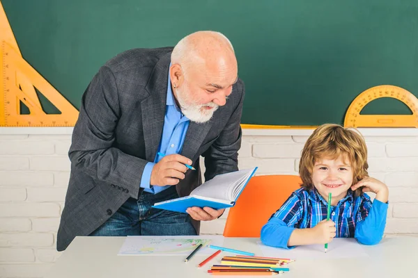 Een grootvader en een zoon leren in de klas. Oud en Jong. Begrip pensioengerechtigde leeftijd. Portret van een zelfverzekerde oude mannelijke leraar. — Stockfoto