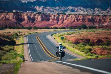 Motosikletli bir sürücü, Route 66, Arizona. Manzaralı bir yolun panoramik resmi, ABD. Ufukta asfalt yolu olan doğal Amerikan manzarası.