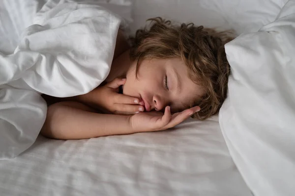 Děti spí v posteli. Dobrou noc. Klidné roztomilé dítě ležící na měkkých polštářích. — Stock fotografie