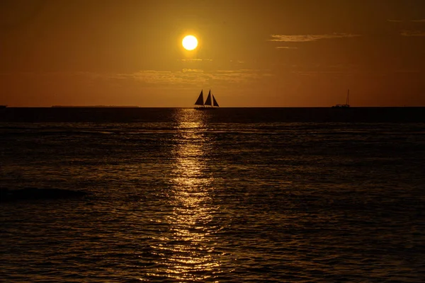 Żaglówka na oceanie o zachodzie słońca. Jacht na tle wschodu słońca. Piękny zachód słońca nad oceanem z łodzi żeglarstwo. — Zdjęcie stockowe
