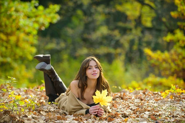 Feliz joven hermosa mujer que pone en hojas de otoño. — Foto de Stock