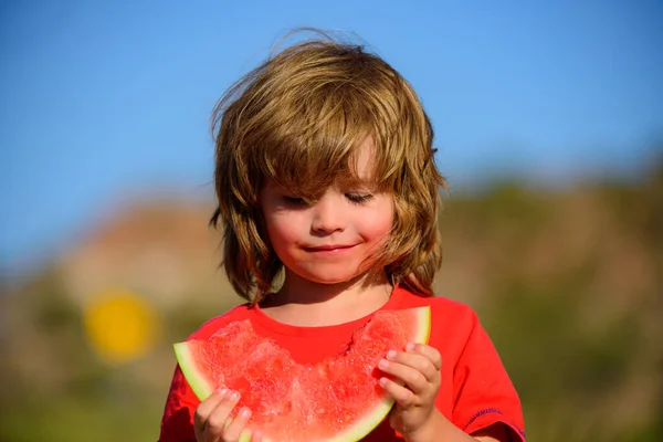 Garoto bonito comendo uma melancia doce . — Fotografia de Stock