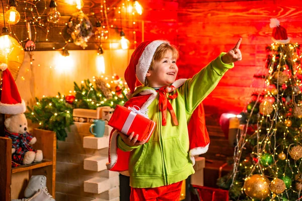 Criança menino feliz com presente ou caixa de presente dentro de casa. Um miúdo engraçado a segurar um presente de Natal. Emoções de presentes. Criança feliz com presente de Natal . — Fotografia de Stock