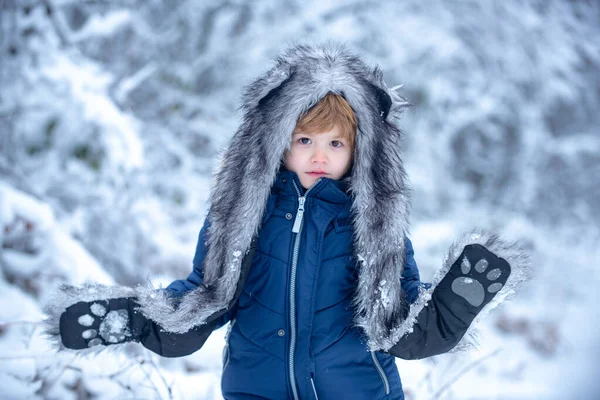 Vinterlandskap av skog och snö med söta barn pojke. Barn springer på snötäckta fält. Pojken drömmer om vintern. Glada barn på naturvandringar på vintern. — Stockfoto