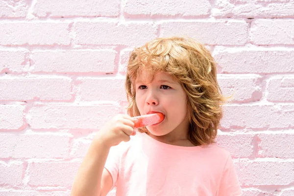 Un bambino gelato. Ragazzino mangiare gelato in uno sfondo rosa. — Foto Stock