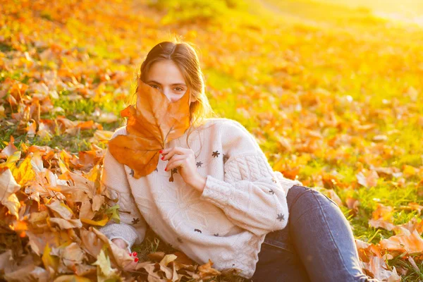 Mulher jovem com folhas de outono na mão e queda de bordo amarelo. Flerte menina sonhadora posando. Beleza de olhos . — Fotografia de Stock