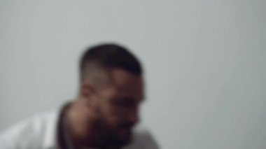 Öfkeli öfkeli saldırgan adam bağırıyor ve gri arka planda izole edilmiş kamerayı işaret ediyor..