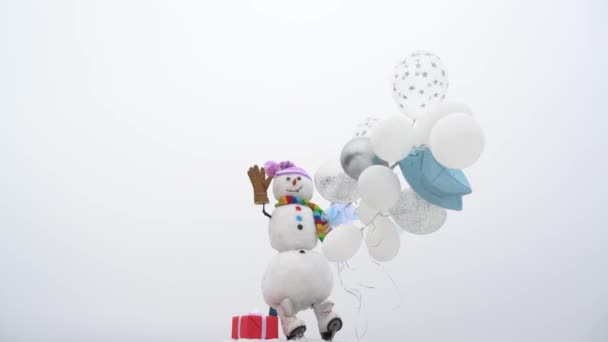 Feliz Natal e feliz ano novo. Boneco de neve feliz em pé na paisagem de Natal de inverno. Homem de neve com presente para você . — Vídeo de Stock