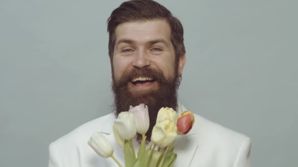 誕生日にチューリップの花束を持つ幸せな男。髭の男は花を持っている。バレンタインデー。女性の日。春休み。面白い感情. — ストック動画