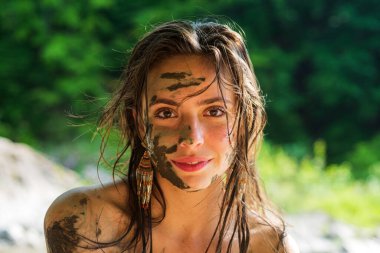 Yüzünde doğal kilden maske olan güzel bir kız..