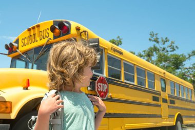 Okula dönelim. İlkokuldan elinde kitap ve çantayla bir çocuk. Eğitim.