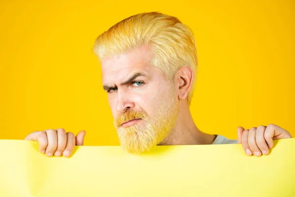 男人拿着一个黄色的空白广告牌隔离在彩色背景下. — 图库照片