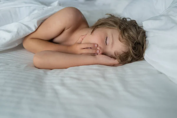 Здоровый мальчик, милый блондин, дети спят в постели. Постельное белье и матрас в спальне. — стоковое фото