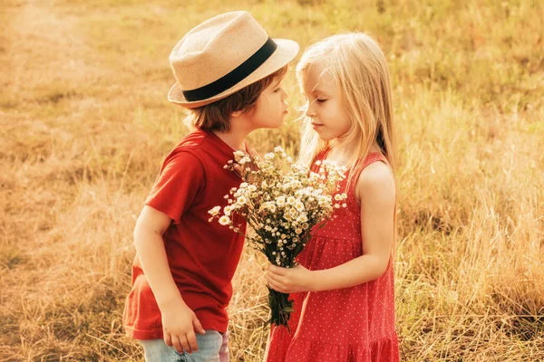 Kinder lieben Konzept. Kinder küssen sich im Herbstfeld. Kleines Paar, das sich küsst und auf dem Land genießt. Glückliche Kindheit. — Stockfoto