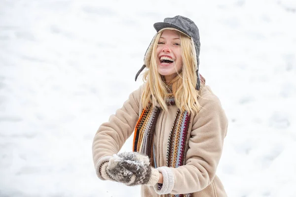 幸せな女性は雪玉を手に持っている。冬の幸せな女の子の肖像画. — ストック写真