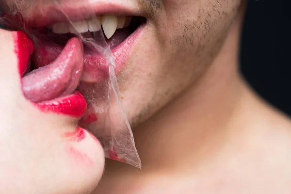 Seksuele activiteit. Seks gezondheid. Een paar kusjes door doorzichtig plastic. Meisje sexy tong likken jongen. Veilige seks. Oraal condoom concept. Bescherming van de gezondheid. Gezondheidsbescherming. Seksueel overdraagbare ziekten — Stockfoto