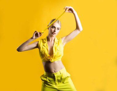 Elinde bir rulo bant tutan genç kız. Seksi kız, izolasyon bandı ya da seloteyp ile yenilenmeye hazır, sarıda izole edilmiş..