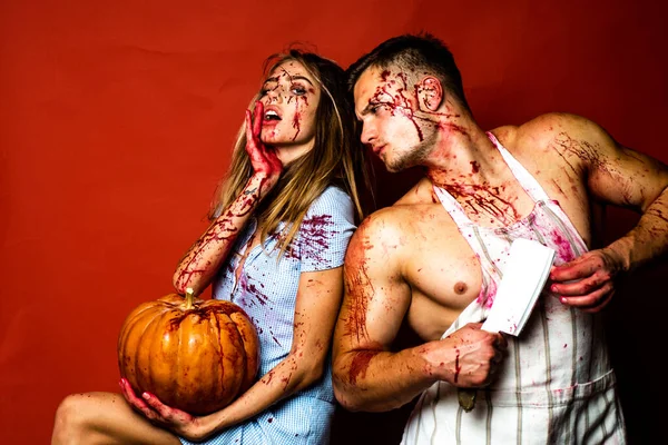 血液中のカップル。赤い背景に赤い隔離されたクレイジーハロウィーンのカップル。ゾンビ夫婦が怖い。血液中の筋肉の男。顔に血が。ひどいハロウィンだ. — ストック写真