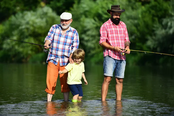 Pesca a mosca. Ragazzino pesca a mosca nel fiume con il padre e il nonno. — Foto Stock