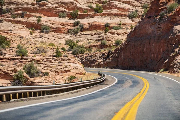 Weg gegen die hohen Felsen. Amerikanische Naturlandschaft mit Asphaltstraße. — Stockfoto