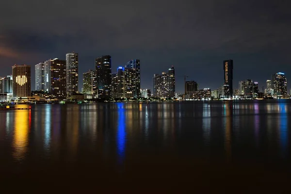 Miami gecesi. Miami Florida, gün batımı manzarası. Biscayne Körfezi 'nde renkli iş yerleri, konut binaları ve köprü.. — Stok fotoğraf