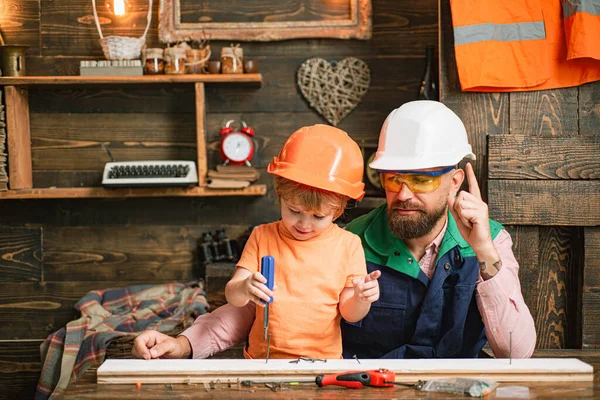 Vader en zijn zoon werken samen in een houten werkplaats. Vroege ontwikkeling. Kindergroei. — Stockfoto