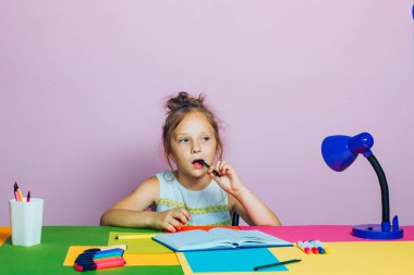 İlkokul öğrencisi. Erken çocuk gelişimi. Okulda küçük şirin bir kız yazıyor..