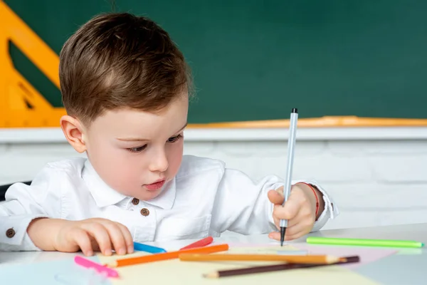 Grabben ritar på papper. Barn lär sig hemma. Barn från grundskolan. — Stockfoto