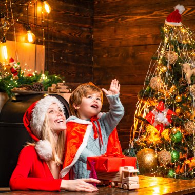 Mutlu aile - Kız ve erkek kardeşler Noel 'i ya da yeni yılı kutluyor. Noel kutlaması tatili. Kışlık giyinmiş küçük mutlu çocuk dikkat çekiyor.