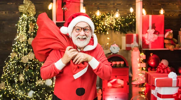 Funny Santa hold Christmas gift. Home Christmas atmosphere. Men in winter clothes. Santa winter portrait. Santa