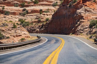 Turuncu taşlı manzara, bulutlu gökyüzü ve yazın asfalt yol. Dağda yaz yolu, Virajlı Arizona Çöl Yolu.