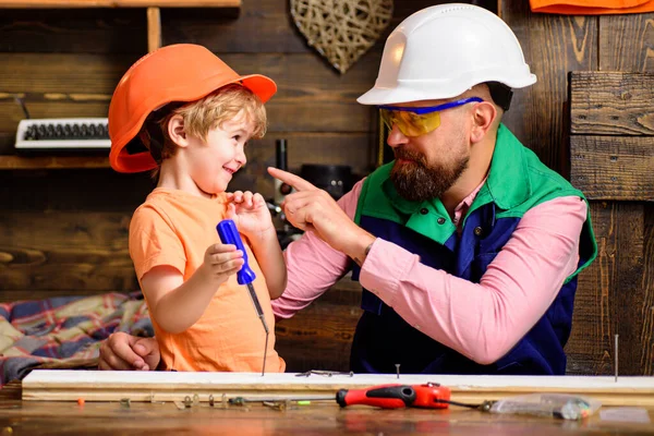Gereedschapsbouw. Vader die kleine zoon leert timmermansgereedschap en hameren te gebruiken. Vader helpt zoon bij workshop. — Stockfoto