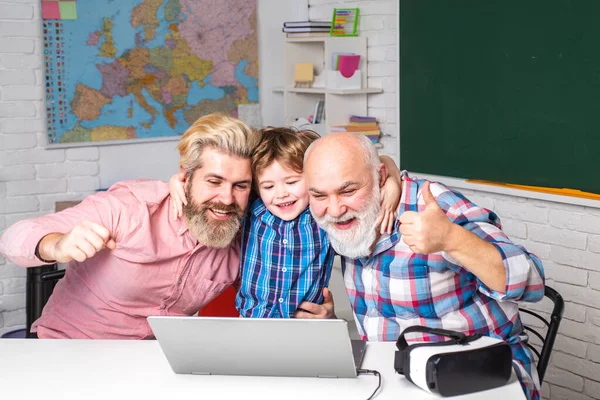 Fathers Day. Happy mature teachers. Senior man using laptop PC with his adult son.