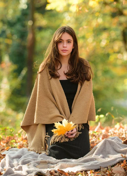 Chica de belleza al aire libre disfrutando de la naturaleza. Hermosa modelo femenino otoño sostiene la hoja amarilla. Mujer retrato de moda con hojas de arce amarillo. Hojas cayendo y concepto de personas. — Foto de Stock