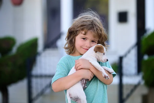 Schattig kind en hond knuffelt haar met tederheid glimlachend. Portret jongen met huisdier. — Stockfoto