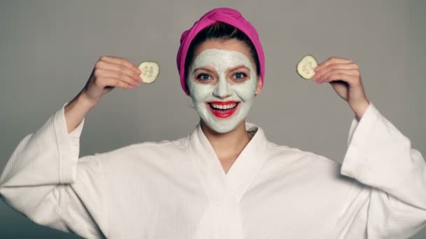 脸上戴着面罩霜的女孩漂亮的女孩和化妆品面霜。护肤面部保健和化妆品治疗. — 图库视频影像