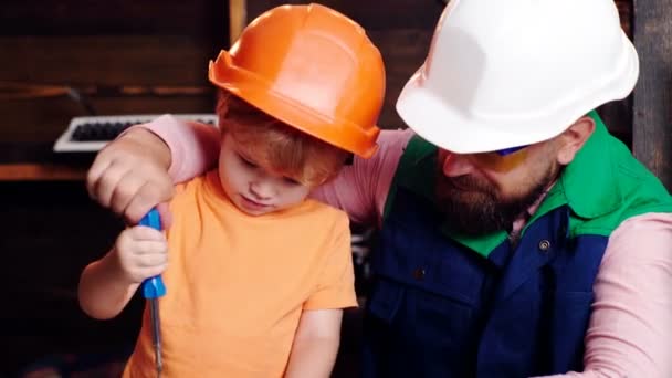 Πατέρας μαθαίνει στο μικρό γιο να χρησιμοποιεί εργαλεία ξυλουργού και σφυρηλάτηση. — Αρχείο Βίντεο